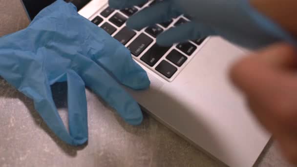 Ordenador portátil con mascarilla médica, bloc de notas y bolígrafo encima junto con una taza de café en la mesa de comedor. En casa. Trabajo en casa concepto. — Vídeo de stock