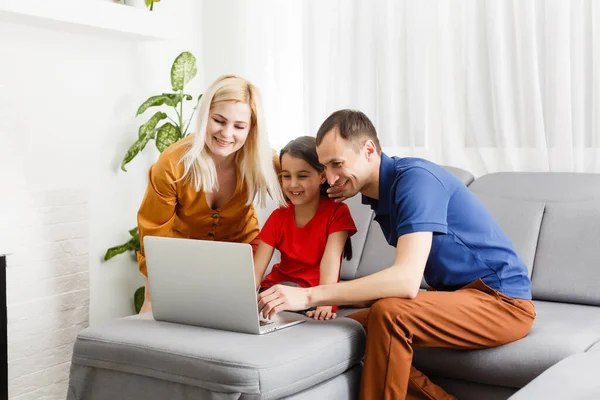 Familj arbetar och studerar på bärbar dator på nätet — Stockfoto