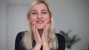 Mutlu genç bir kadın görüntülü konuşuyor. Konuşurken kahkaha atıyor. İnternette sohbet ediyor. Web kameralarına bakıyor.