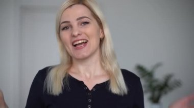 Mutlu genç bir kadın görüntülü konuşuyor. Konuşurken kahkaha atıyor. İnternette sohbet ediyor. Web kameralarına bakıyor.