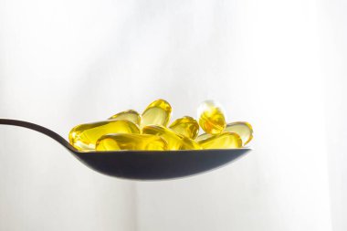 Omega 3 kaşığında morina yağı kapsülleri.