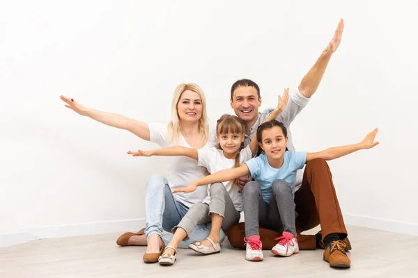 Les jeunes parents souriants et leurs enfants sont très heureux, ils sont à la maison — Photo