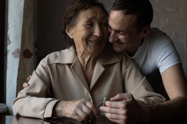 A very old woman and an adult grandson — Stock Photo, Image