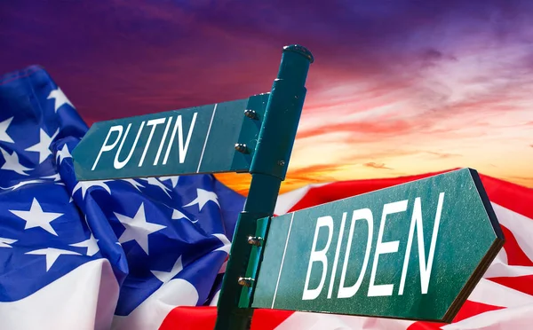 Αντιπαράθεση μεταξύ Ρωσίας και Αμερικής. Τα ονόματα των Προέδρων στην πινακίδα στην άκρη του δρόμου στο φόντο της αμερικανικής σημαίας και ενός θυελλώδους ουρανού — Φωτογραφία Αρχείου