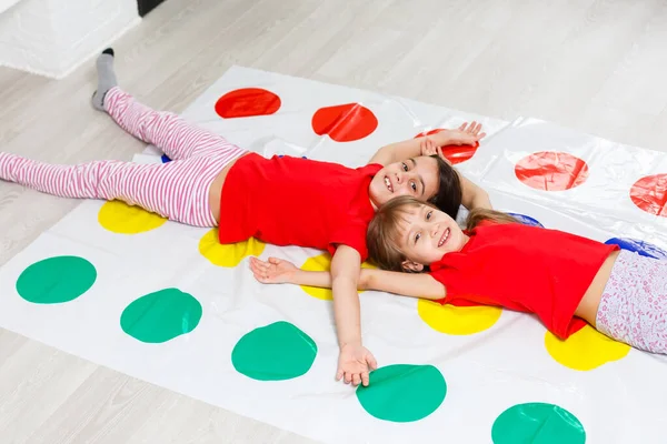 Dvě malé holčičky baví hraní hry na podlaze doma. Přátelství sourozenců — Stock fotografie