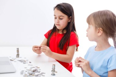 İki çocuk birlikte bozuk para sayıyor.