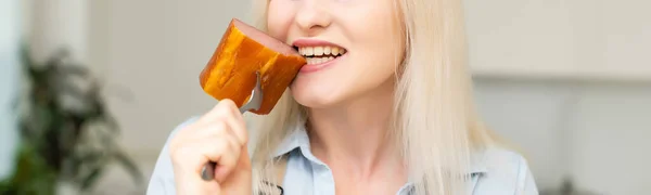 Atraktivní mladá žena drží klobásu na vidličce — Stock fotografie