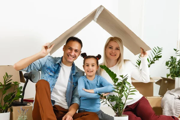 Οικογένεια ξεπακετάρισμα χαρτονένια κουτιά στο νέο σπίτι — Φωτογραφία Αρχείου