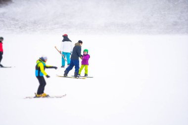 Soğuk Rüzgâr Günü 'nde Dağ Kayağı Tatil Köyü' nde Baba Küçük Kızına Snowboard öğretiyor