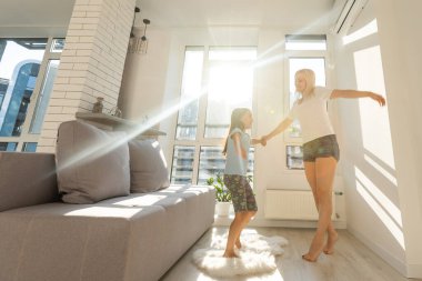 Anne kızıyla odada dans ediyor.