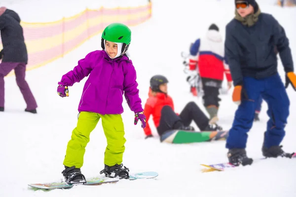 Kicsi Aranyos Lány Snowboard síközpont napsütéses téli nap. — Stock Fotó