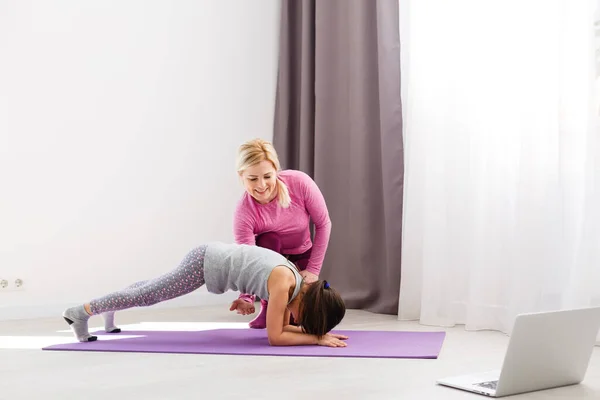 La ragazza fa ginnastica a casa. Video tutorial di ginnastica. Esercizi ginnici. L'idea di un'attività per bambini in quarantena — Foto Stock