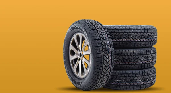 Car tires isolated on yellow background — Stock Photo, Image