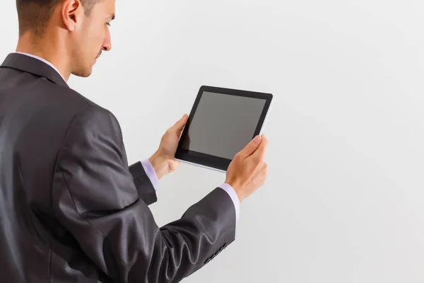 The businessman holding tablet against white background — Stock Photo, Image