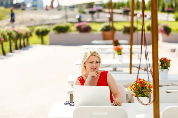 Jeune jolie femme avec ordinateur portable sur le banc dans un parc — Photo