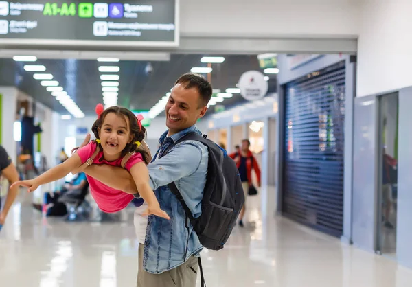 Давай найдем наш рейс. Вид на счастливых отца и дочь в аэропорту в терминале — стоковое фото