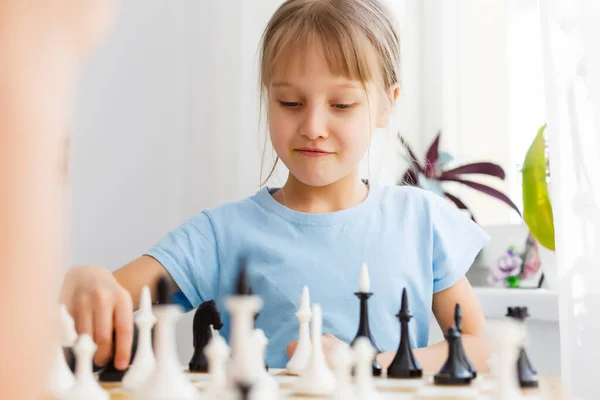 Niña jugando al ajedrez en una mesa — Foto de Stock