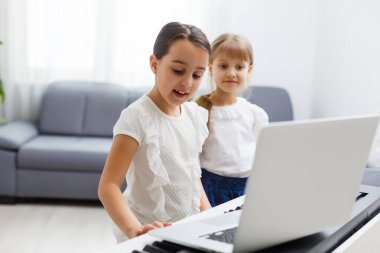 Piyano çalan kız için ev müziği dersi. Karantina sırasında çocuk için evde aktivite fikri. Müzik konsepti