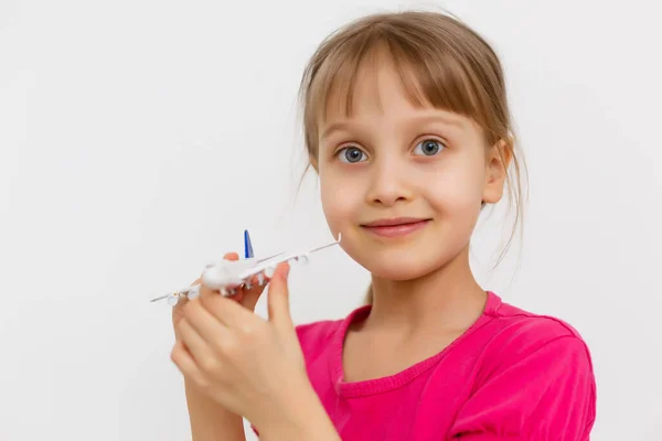 Słodka dziewczynka bawiąca się zabawkowym samolotem. Izolacja na białym tle — Zdjęcie stockowe
