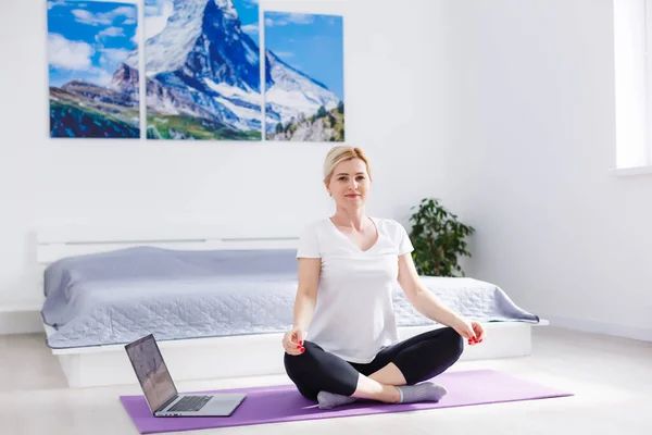 Boldog nő gyakorolja, miközben nézi edzés videó laptop otthon — Stock Fotó