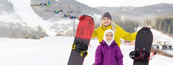 Mère et fille avec snowboards à la station d'hiver — Photo