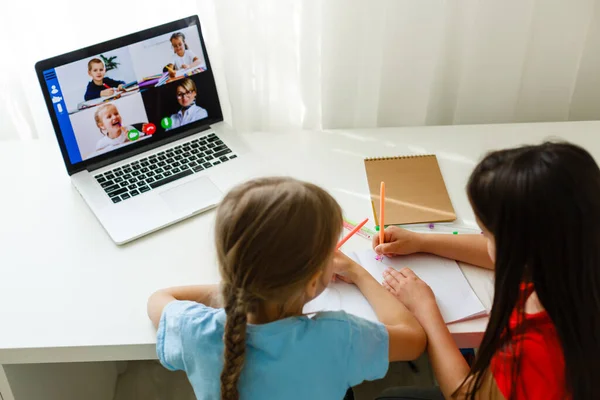 Escola online fixe. Crianças estudando on-line em casa usando um laptop. Jovens garotas alegres usando o computador portátil estudando através do sistema de e-learning online. Ensino à distância ou à distância — Fotografia de Stock