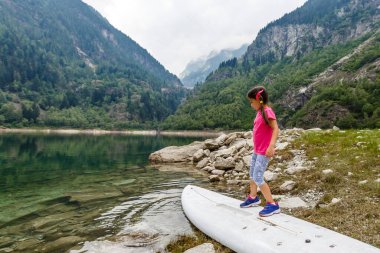 Küçük kız İtalya dağlarına bakıyor.