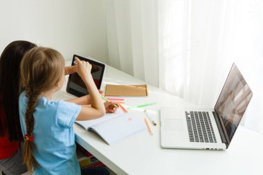 Evde öğreniyorum, evde öğreniyorum. Küçük çocuklar evde bilgisayarla online öğrenim görüyorlar. Karantina ve Sosyal Mesafe.
