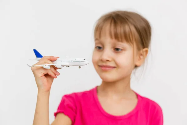 Liten flicka leker med en leksak flygplan — Stockfoto