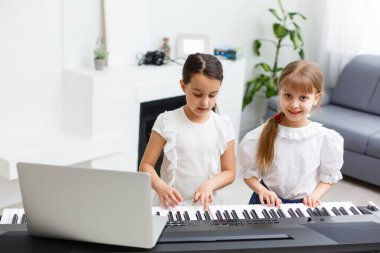 Piyano çalan kız için ev müziği dersi. Karantina sırasında çocuk için evde aktivite fikri. Müzik konsepti