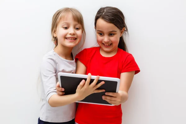 Foto van twee mooie meisjes met tablet pc op witte achtergrond — Stockfoto