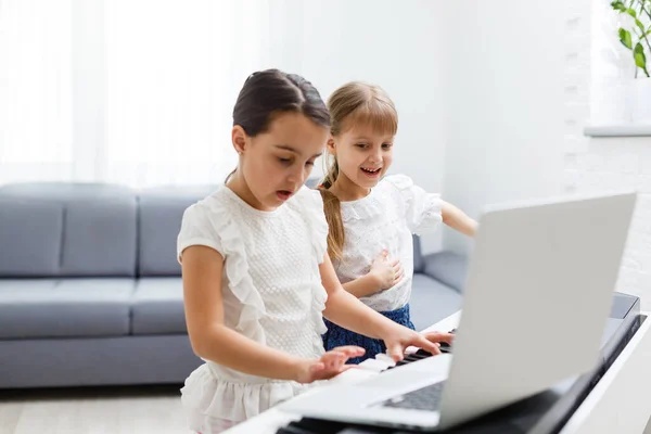 Cours de piano à domicile. deux filles pratiquent la partition sur un instrument de musique. Concept de famille. L'idée d'activités pour les enfants en quarantaine. — Photo