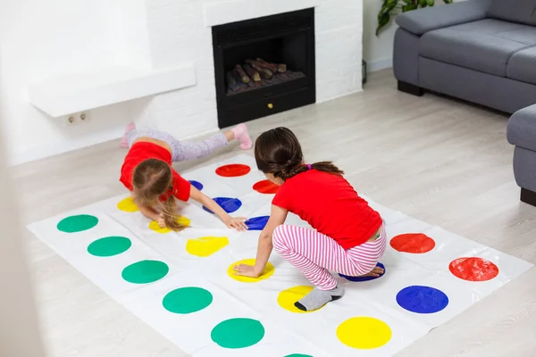 Twee kleine meisjes hebben plezier spelen spel op de vloer thuis. Vriendschap tussen broers en zussen — Stockfoto