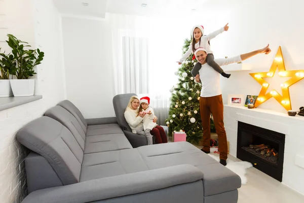 Feliz jovem família segurando presente de Natal e sorrindo para a câmera — Fotografia de Stock