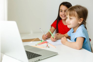 Evdeki online dersi sırasında matematik okuyan oldukça şık okul kızları, karantina sırasındaki sosyal mesafeler, kişisel izolasyon, çevrimiçi eğitim kavramı