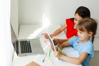 Evde öğreniyorum, evde öğreniyorum. Küçük çocuklar evde bilgisayarla online öğrenim görüyorlar. Karantina ve Sosyal Mesafe.