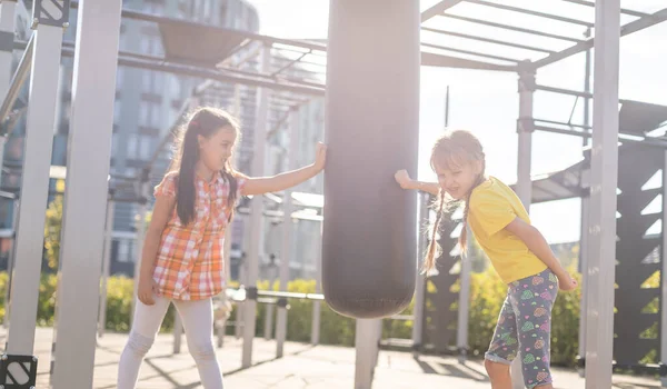 Két aranyos kislány szórakozik egy játszótéren a szabadban nyáron. Sportolási lehetőségek gyerekeknek. — Stock Fotó