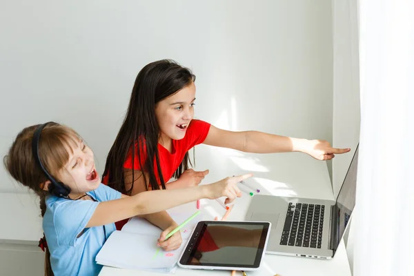 Leuke online school. Kinderen die thuis online studeren met een laptop. Vrolijke jonge meisjes met behulp van laptop computer studeren via online e-learning systeem. Afstandsonderwijs of afstandsonderwijs — Stockfoto