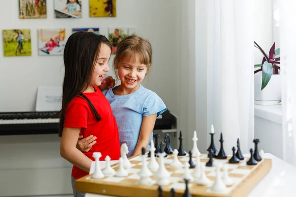 Dos lindos niños jugando ajedrez en casa — Foto de Stock