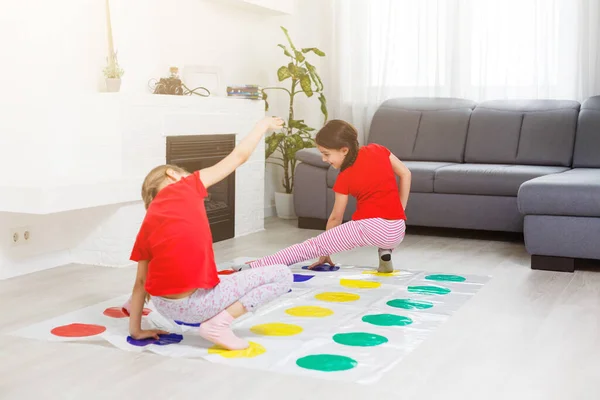 Dos niñas divirtiéndose jugando en el piso en casa. Amistad de hermanos — Foto de Stock