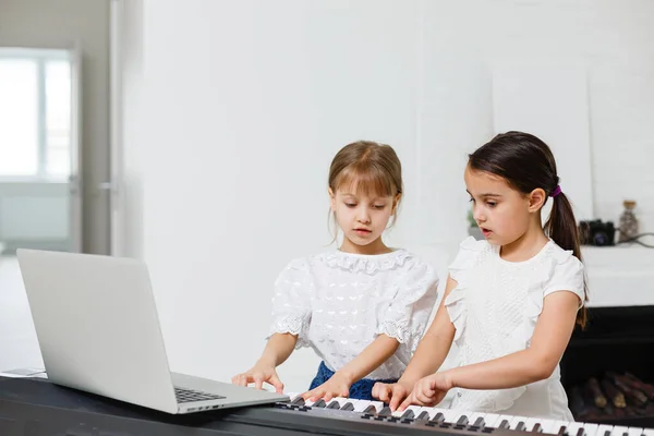 Cours de piano à domicile. deux filles pratiquent la partition sur un instrument de musique. Concept de famille. L'idée d'activités pour les enfants en quarantaine. — Photo