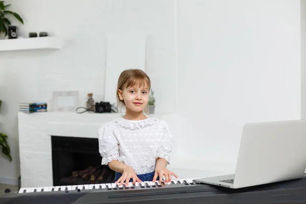 Accueil leçon de musique pour la fille au piano. L'idée d'activités pour l'enfant à la maison pendant la quarantaine. Concept de musique — Photo
