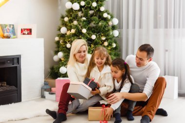 Mutlu aile evde Noel hediyeleriyle oynuyor.