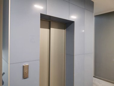 Tek asansör kapısı, mavi fayanslar.