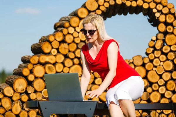 Młoda piękna kobieta z laptopem na ławce w parku — Zdjęcie stockowe