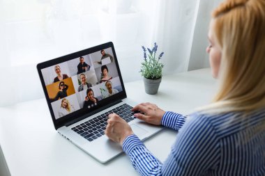 Bir kadın uzaktan video konferans ve toplantıları kullanarak çalışıyor ve evden uzaktan çalışıyor, başarılı bir iş.