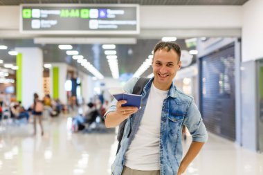 Terminaldeki havaalanında sırt çantalı genç bir adam.