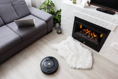 Yerde robotik süpürge var.