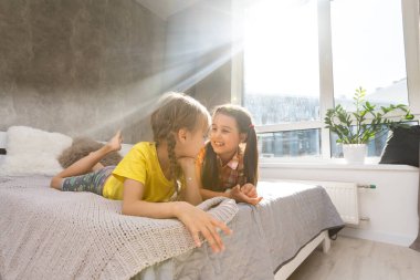 Küçük kız kardeşler birlikte yatakta.