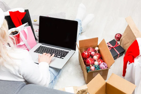 크리스마스 파티 준비중이야. 노트북에 선물과 장식을 주문하고 선물 상자와 패키지 사이에 앉아 복사하는 여성들 — 스톡 사진